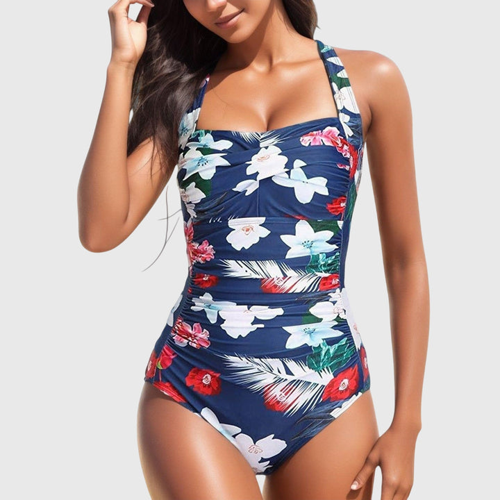 One-piece swimsuit, navy with white floral and green leaf print and ruched fit.