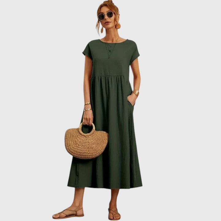 Dark green midi dress with short sleeves and gathered waist seam; relaxed fit.