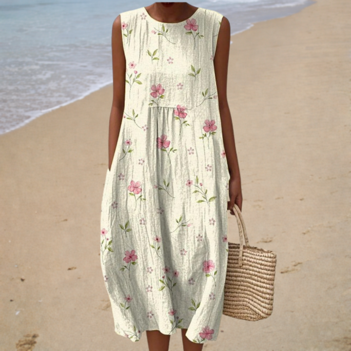 Sleeveless summer dress with round neckline and pink floral print, gathered waist and flowy skirt