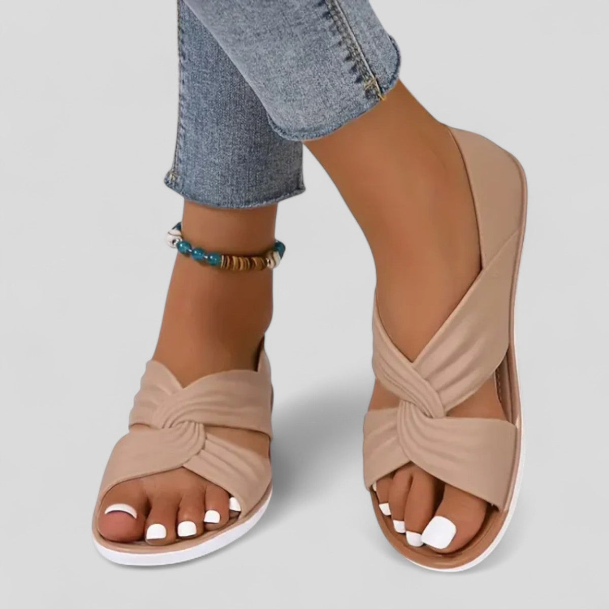 Beige orthopedic sandals with open toe and knotted crossover strap, grippy white outsole