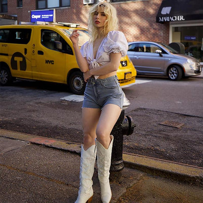 High-waisted denim crossover-style summer shorts with frayed hem and front button closure