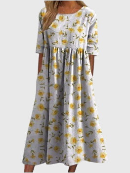 Relaxed midi dress in white with yellow daisy-like floral print, short sleeves, gathered skirt