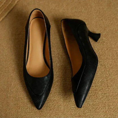 Pair of black pointed-toe pumps with low block heels.