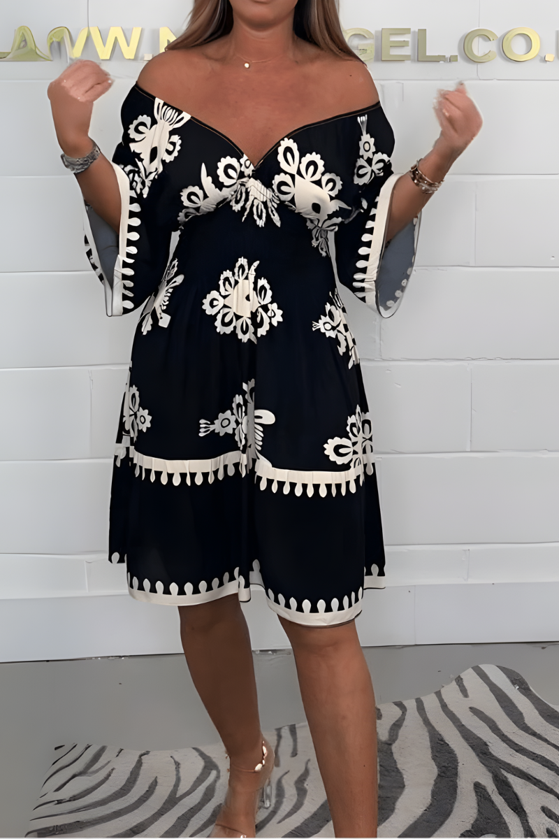Black knee-length dress with white embroidered florals and tassel-trim hem and sleeves