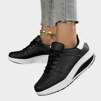 Black orthopedic sneakers with white sole trim, lace-up front, and textured side tread