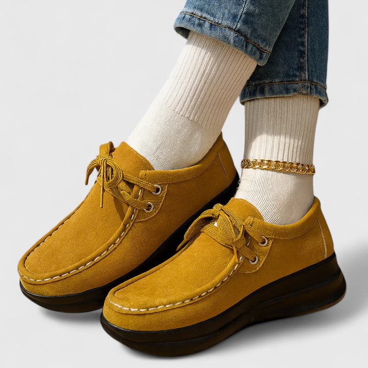 Mustard lace-up orthopedic shoes with suede upper and thick dark sole.