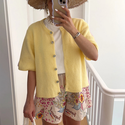 Yellow short-sleeve button-front knit cardigan with ribbed texture and rounded collar.