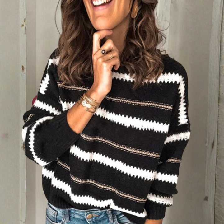 Crewneck sweater with long sleeves; black knit with white and tan horizontal stripes.
