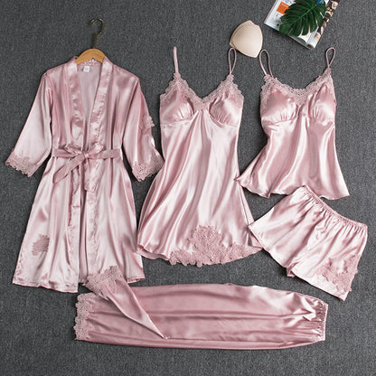 Women’s pink satin nightwear set with lace-trim robe, camisole, and matching shorts