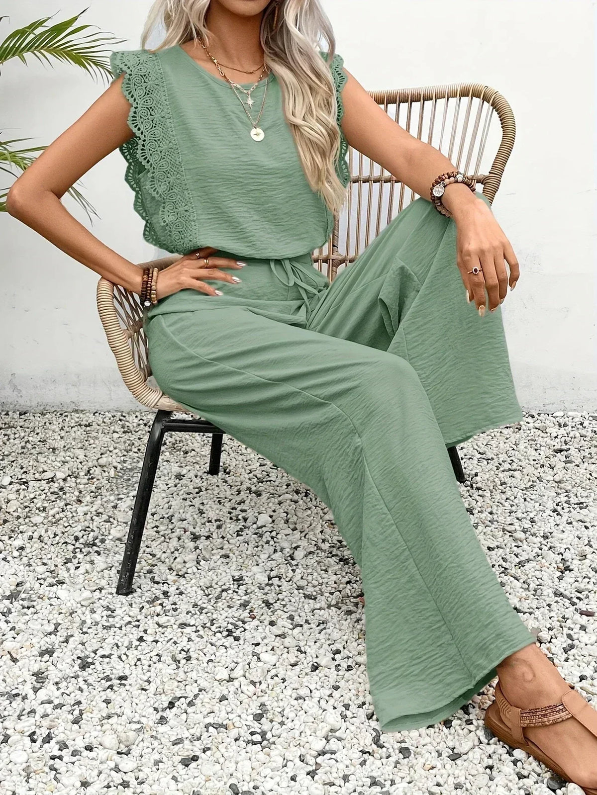 Women’s green lace-trim sleeveless top with drawstring waist wide-leg pants set, seated