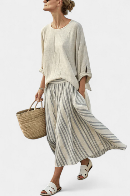 Cream blouse with three-quarter sleeves and gray-and-white striped midi skirt