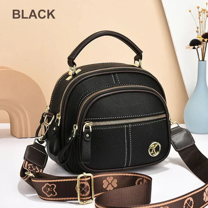 Mini chic crossbody shoulder bag in black with gold-tone hardware and zip compartments
