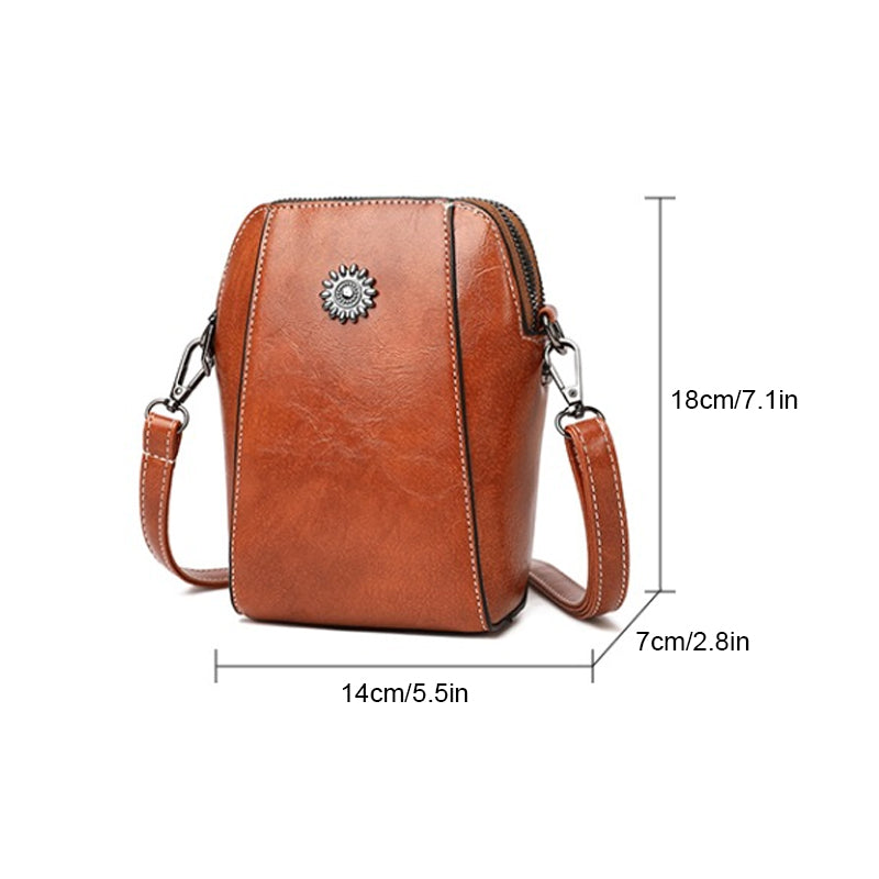 Brown compact mini handbag with crossbody strap, zipper top, and decorative sunburst emblem.