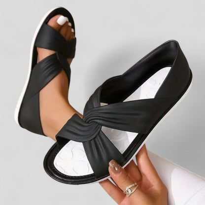 Black orthopedic sandals with knotted crossover strap and cushioned footbed, side view