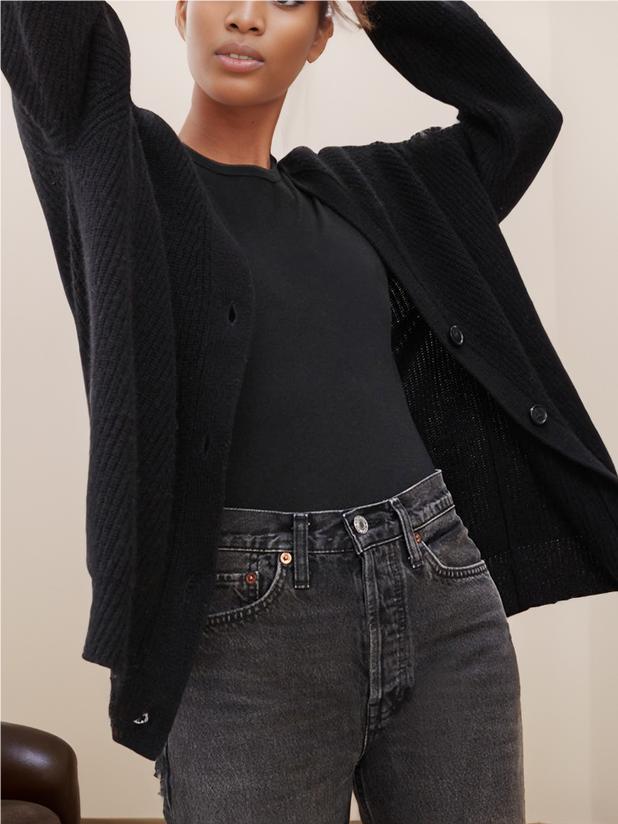Black knit cardigan, open V-neck with buttons, long sleeves, relaxed fit over dark top.