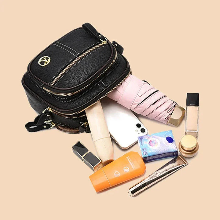 Black mini crossbody shoulder bag with top handle, zip front pocket, and adjustable strap