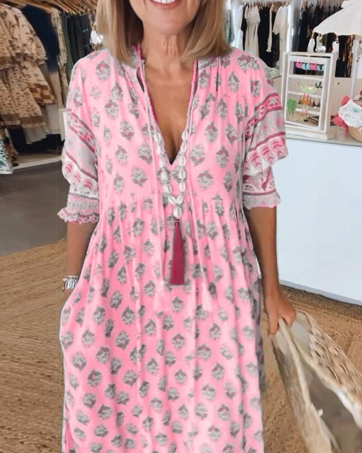 Pink floral V-neck tiered dress with ruffle sleeves and tasseled drawstring neckline