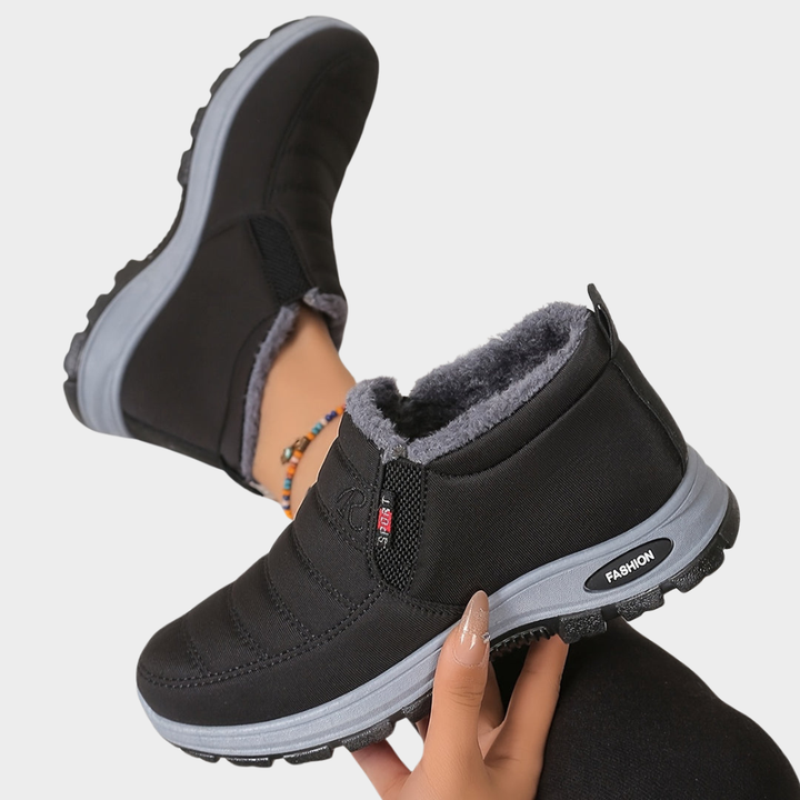 Black fur-lined ankle boots with elastic side and chunky gray outsole