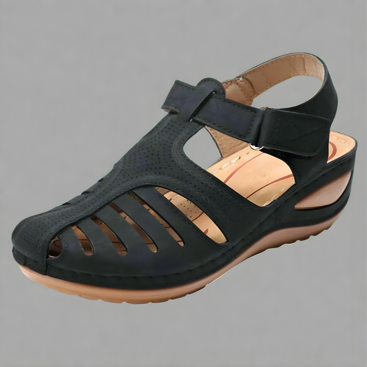 Orthopedic bunion corrector sandal, dark leather-look with wide strap and cushioned sole.