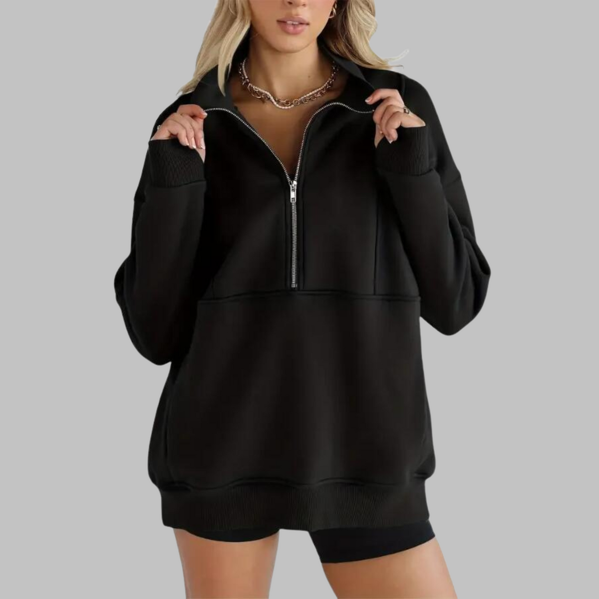 Black oversized half-zip long sleeve sweatshirt with ribbed cuffs, collar, and front pocket