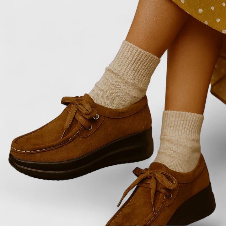 Tan lace-up orthopedic shoe with suede upper and thick dark sole.