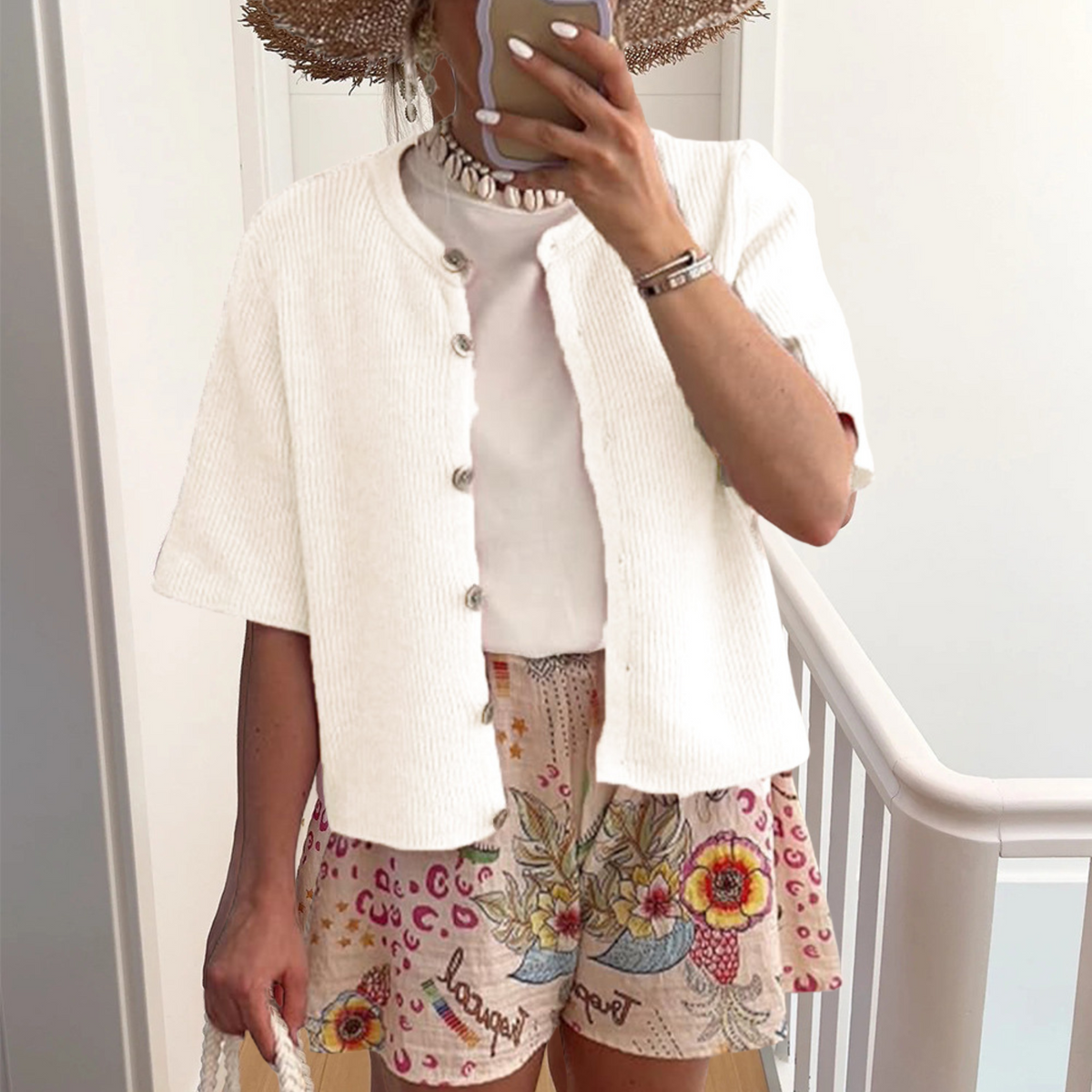 White short-sleeve button-front knit cardigan with ribbed texture and rounded collar.