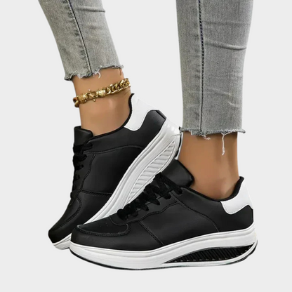 Black orthopedic sneakers with white side panels, lace-up front, and thick cushioned sole
