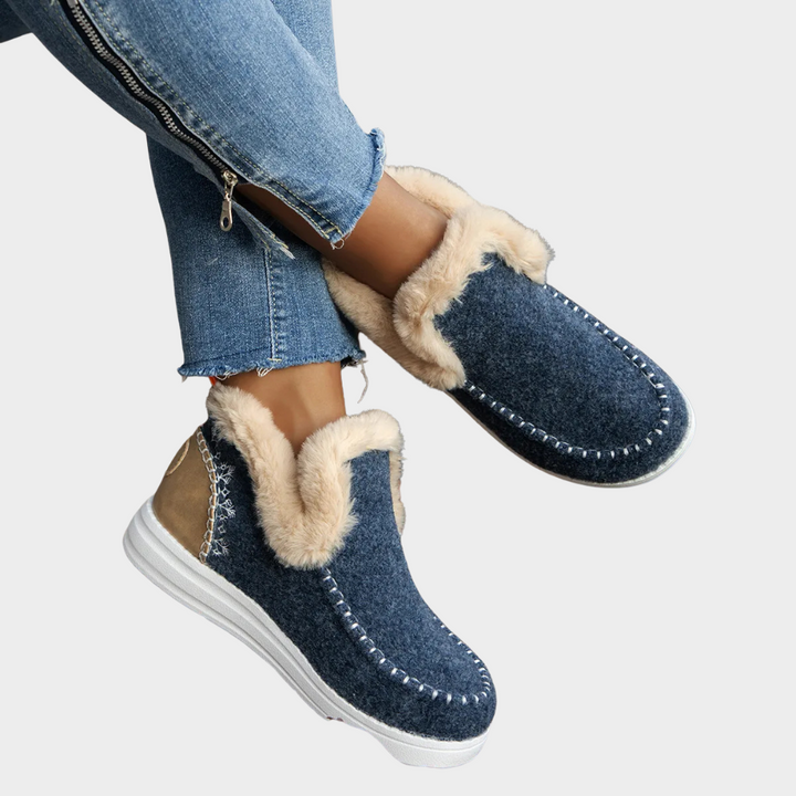 Cozy slip-on boots in navy blue with faux-fur lining and white contrast stitching