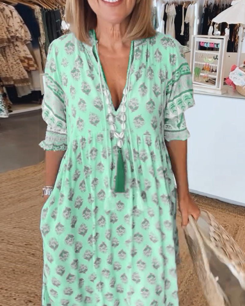 Green floral V-neck tiered dress with ruffle sleeves and tasseled drawstring detail