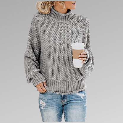 Grey oversized winter sweater, chunky knit texture, ribbed turtleneck cuffs