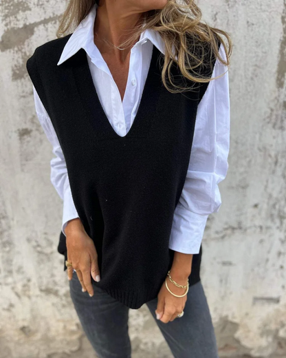 Black knit sweater vest over a white button-down, V-neck and sleeveless cut.