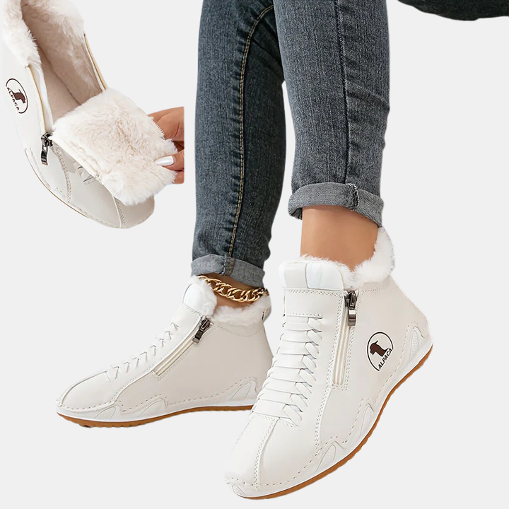 White ankle boots with faux fur cuff and side zipper, lace-up style, tan sole.