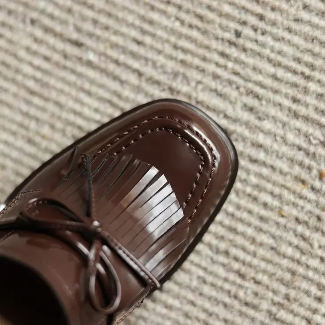 Brown loafer pump toe with saddle seam and rounded strap collar