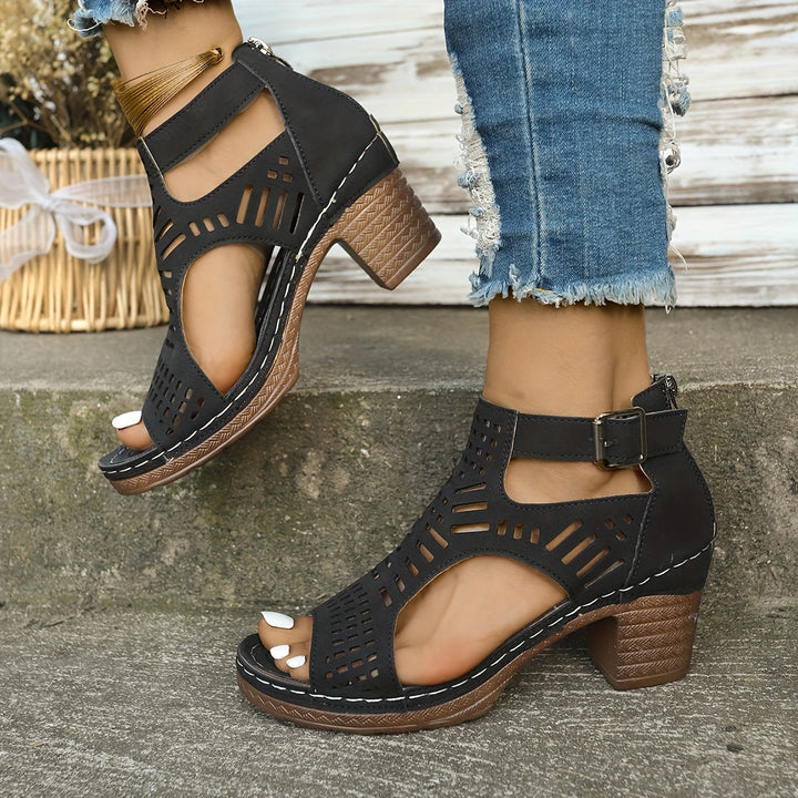 Black ergonomic sandals with cutout straps, buckle ankle, and chunky block heel