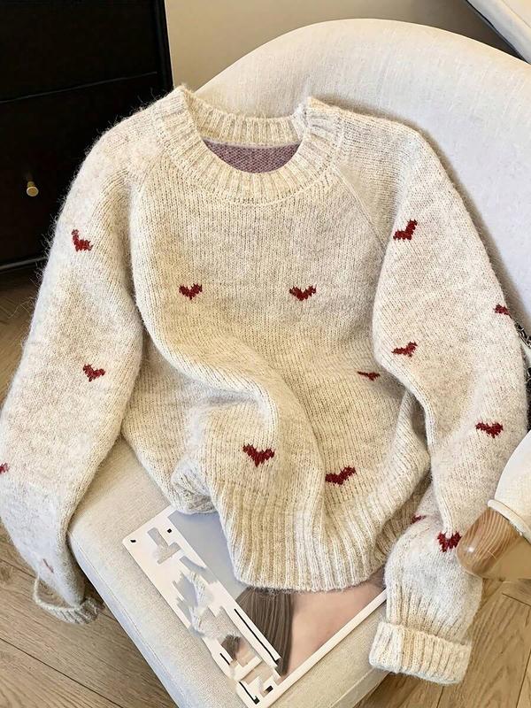 Cream knit sweater with red heart pattern and ribbed crew neck, cuffs, and hem