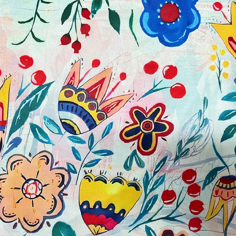 Women’s floral blouse pattern close-up with blue, red, yellow blossoms and leaves