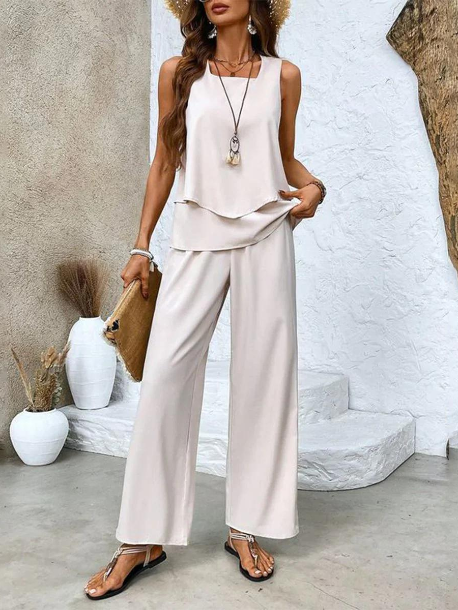 White sleeveless blouse and wide-leg trousers set with layered drape hem