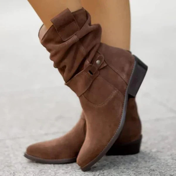 Brown suede ankle boots with side zipper, buckle strap, and low block heel