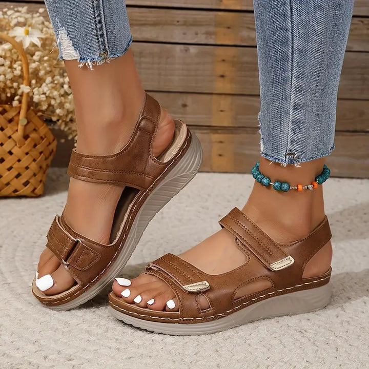 Brown orthopedic sandals with two hook-and-loop straps and cushioned wedge sole
