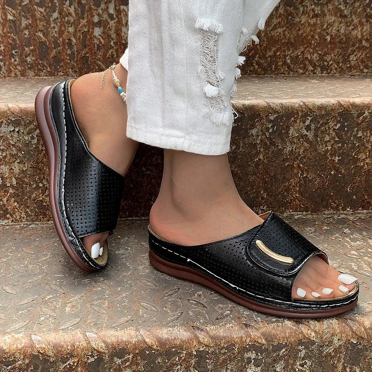 Black perforated slip-on sandals with curved strap and cushioned sole