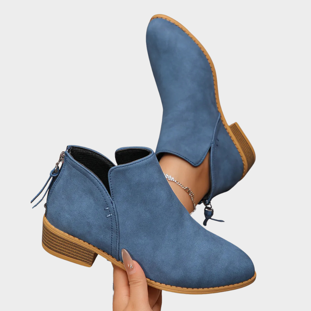 Blue suede ankle boot with side tie, round toe, and tan textured outsole