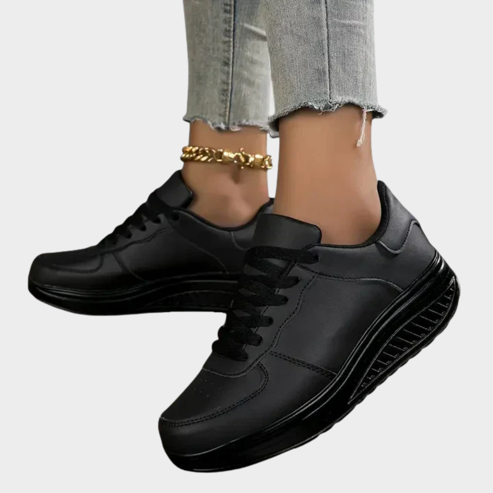 Black orthopedic sneakers with lace-up front, smooth leather upper, and ridged side sole