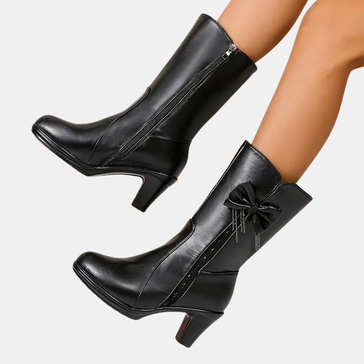 Vintage bow leather boots, black, angled view with side zipper and bow ornament