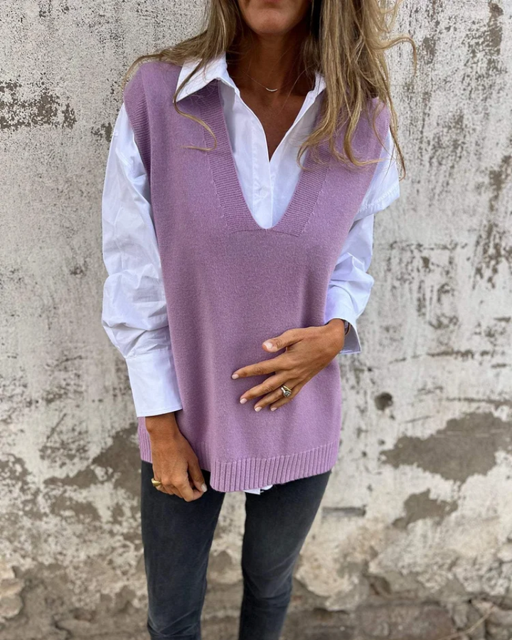 Purple knit sweater vest over a white button-down, V-neck sleeveless with ribbed hem.