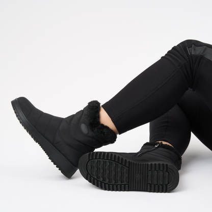 Black ankle boots with faux fur cuff and side zipper; treaded outsole visible