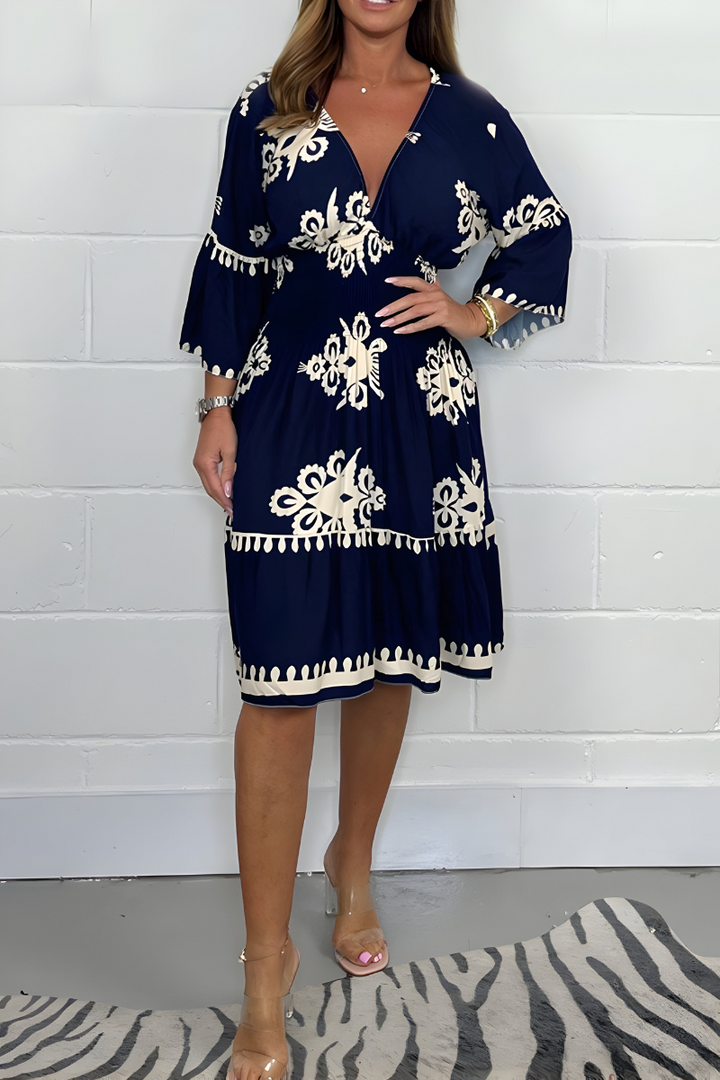 Navy knee-length dress with white embroidered florals and scalloped tassel trim