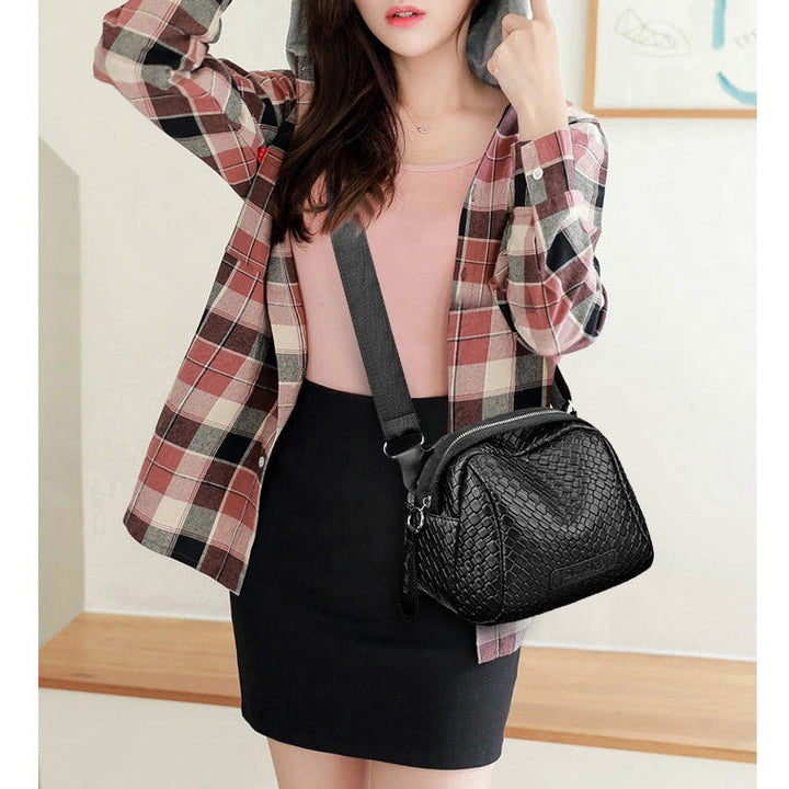 Black woven-texture mini crossbody bag with zip top and short strap, side view