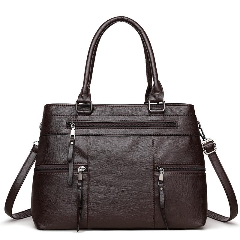 Dark brown leather women’s tote bag with double top handles, front zip and side pockets