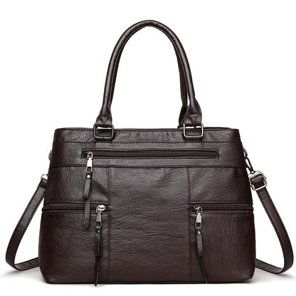 Dark brown leather women’s tote bag with double top handles, front zip and side pockets