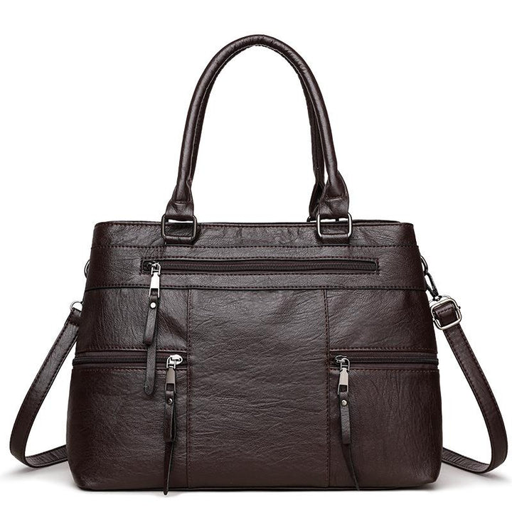 Dark brown leather women’s tote bag with double top handles, front zip and side pockets